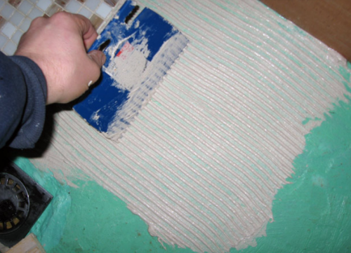 applying adhesive on the mosaic